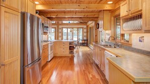 Une cuisine spacieuse dotée de meubles en bois, d’appareils électroménagers en acier inoxydable et d’un îlot central.