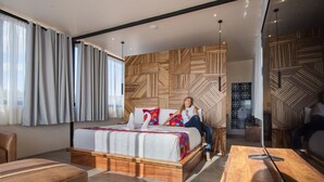 A modern hotel room with a large bed, wooden headboard, and a dining area with a wooden table. - SUITE DAWN (Oaxaca de Juárez)