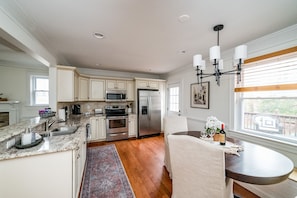 Enjoy cooking and dining in this well-equipped kitchen with a central island, sink, stove, and refrigerator.