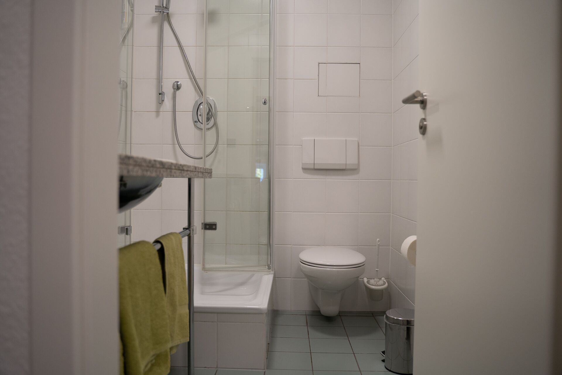 A small, clean bathroom with a shower, toilet, and sink.