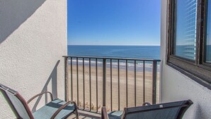 Uma varanda com vista para a praia e o oceano.
