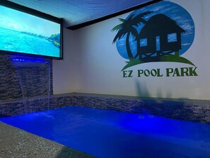 Allasalue, jossa on suuri näyttö, jolla esitetään kaunis maisema, sekä «EZ Pool Park» -logon sisältävä tiiliseinä.