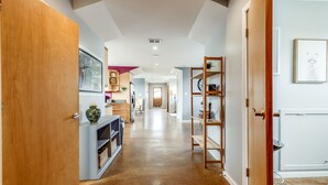 A hallway with a wooden door, a white cabinet, and a bookshelf. - ⭐️Walk to Forsyth Park & River St•Historic Downtown•Private Patio⭐️ (Savannah)