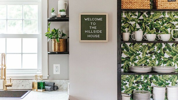 A kitchen with a white countertop, a gold faucet, and a sign that reads "WELCOME TO THE HILLSIDE HOUSE". - Cozy Farmhouse by Shenandoah with Mountain Views (2, East Luray)
