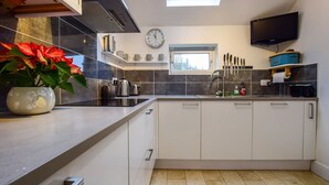 Una cucina moderna con un'ampia finestra, una sveglia e una televisione a schermo piatto.