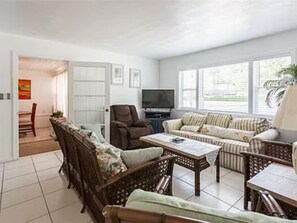 Relax in this spacious living room with a sofa set, television, and dining area.