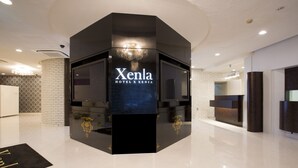 A modern hotel reception area with a black reception desk labeled "Xenla Hotel & Xenia." - Hotel Xenia Juso - Adults Only (Osaka)