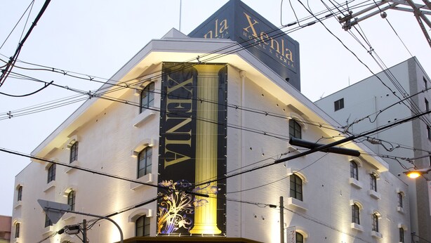 A hotel with a prominent vertical sign reading "Xenia HOTEL XENIA" and a large illuminated column. - Hotel Xenia Juso - Adults Only (Osaka)