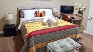 A neatly arranged hotel room with a bed, bedside lamps, a television, and a desk with a computer. - ❤️Executive Suite❤️By 2 Shopping Centres, Costco ... (Grande Prairie)