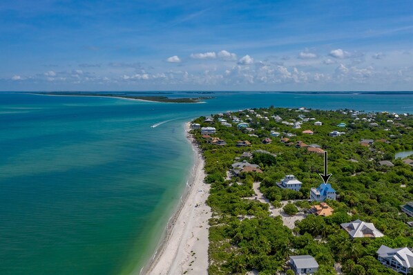 An aerial view of a coastal residential area with houses, a beach, and clear blue waters. - FALL SPECIALS! Captiva Beach Sunset: Beachfront, Private Pool, 2 Carts included (Captiva)