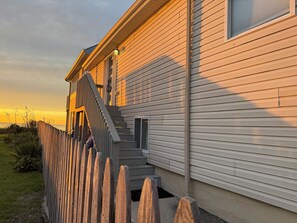 Une maison avec une façade en bois, un escalier apparent et une petite fenêtre.