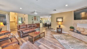 A spacious living room with a leather sofa, wooden coffee table, and a fireplace.