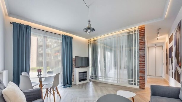 Ein modernes Wohnzimmer mit Sofa, Couchtisch und Fernseher.