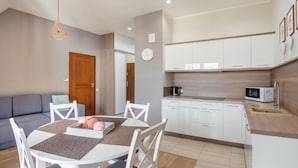 Un espacio habitable compacto con comedor, kitchenette y sofá.