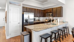 Eine moderne Küche mit Granit-Arbeitsplatten, Edelstahlgeräten und dunklen Holzschränken.