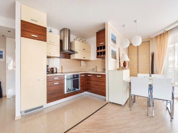 Een moderne keuken met houten kastjes, een roestvrijstalen afzuigkap en een inbouwoven.