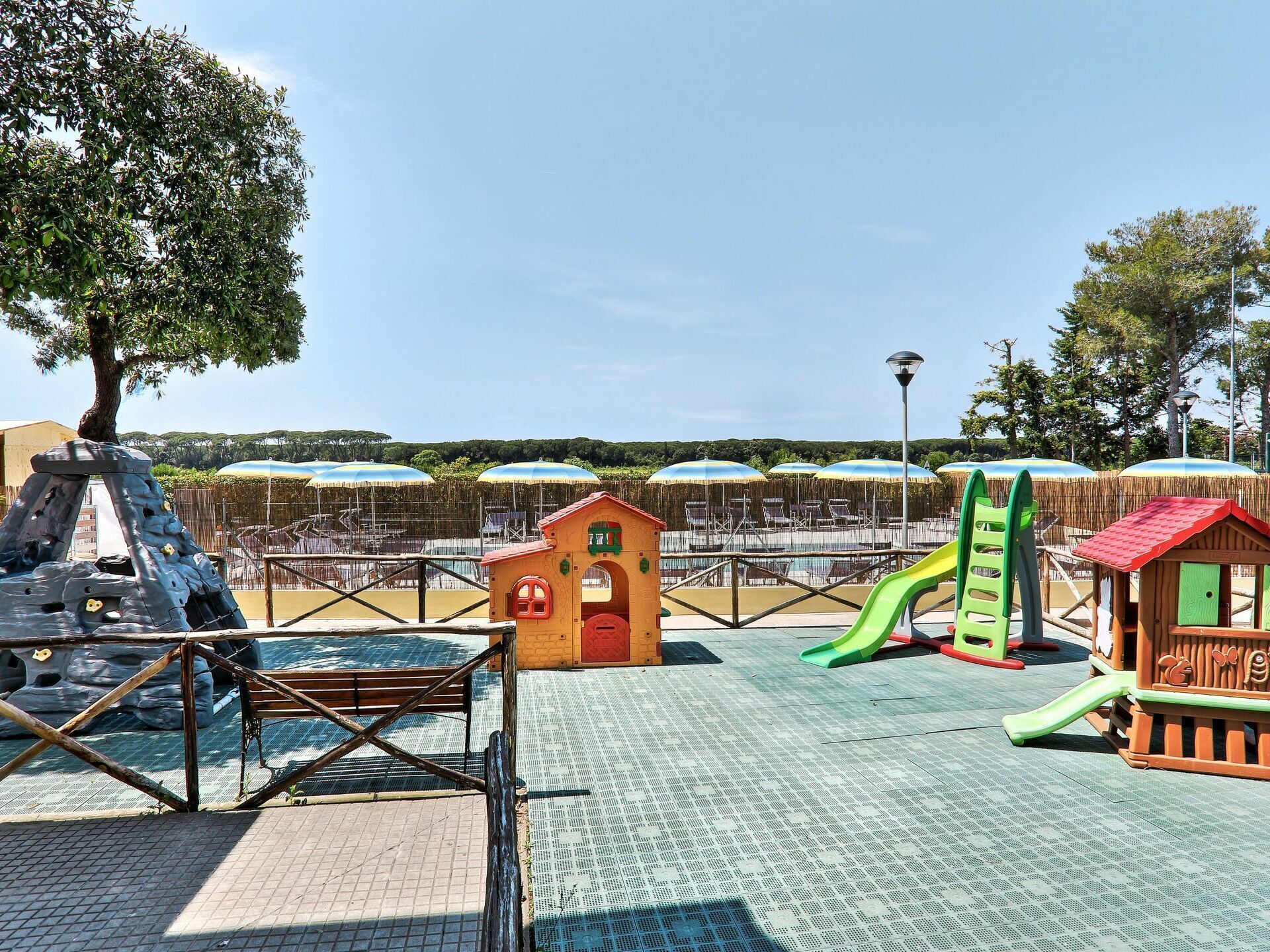 A playground with climbing structures, slides, and small playhouses.