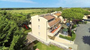 Un edificio de varios pisos con techo plano, un espacio de estar al aire libre cubierto y un parque infantil.