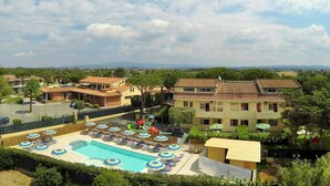 Un resort con piscina, sillas de descanso y sombrillas.