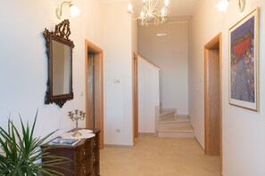 A hallway with a wooden staircase, a large mirror, and a framed painting on the wall. - Pool Villa Dia /w Sauna & Jacuzzi near Dubrovnik, Brsečine, Croatia (Brsečine)