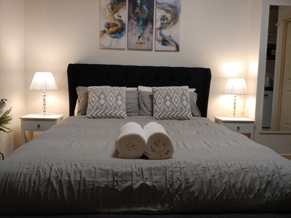 Cozy retreat with a large bed, two bedside tables, and wall art.