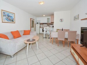Una sala de estar moderna con un sofá, una mesa de centro y un comedor con sillas y una mesa.