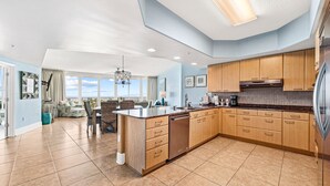 A spacious kitchen with wooden cabinets, a dishwasher, and a large island.