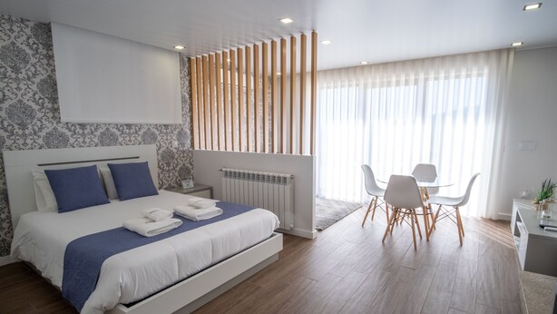 Une chambre d’hôtel moderne, dotée d’un grand lit, d’un bureau et d’un coin repas.