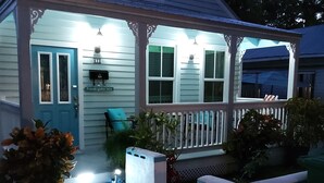 A house with a porch, a door, and a small outdoor seating area.