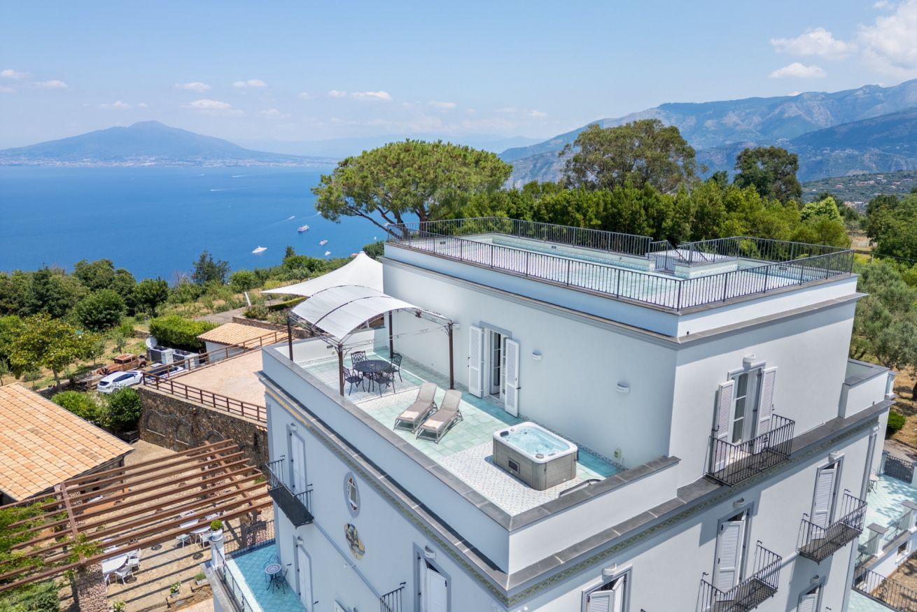 A modern building with a rooftop pool and a view of the sea.