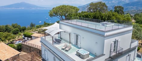 A modern building with a rooftop pool and a view of the sea.
