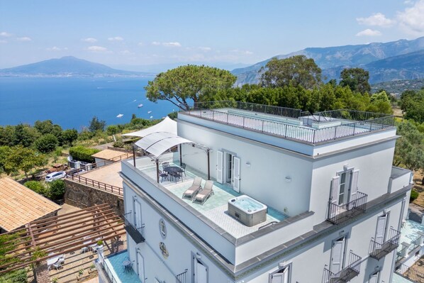 A modern building with a rooftop pool and a view of the sea.