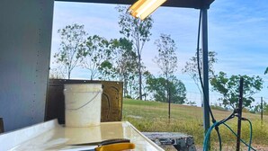 Una zona de cocina con encimera, un cubo y una manguera.