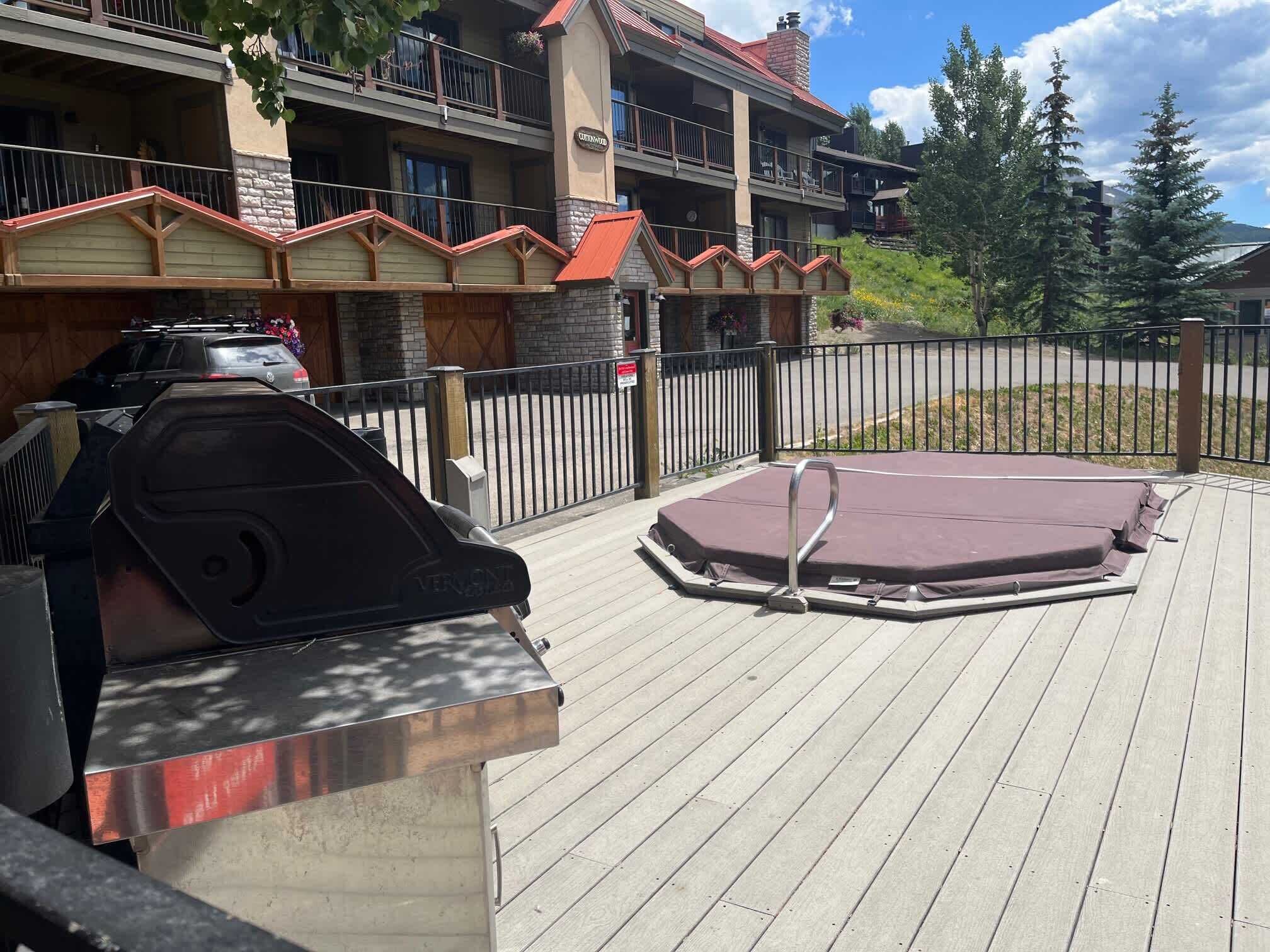 Una terraza con una parrilla y un jacuzzi.