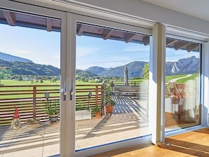A balcony with a view of a green landscape and mountains.