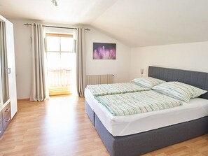A bedroom with a bed, curtains, a radiator, and a window with a view. - Bergblick Acht, Österreich (Innerschwand am Mondsee)