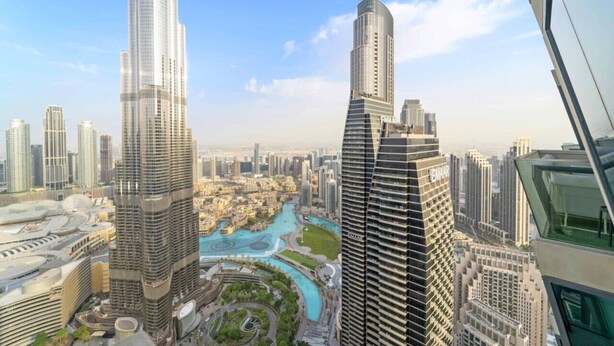 A high-rise building with a modern design, featuring a prominent glass facade and a unique curved structure. - FIRST CLASS | 3BR | Burj Khalifa & Fountain view (Downtown)