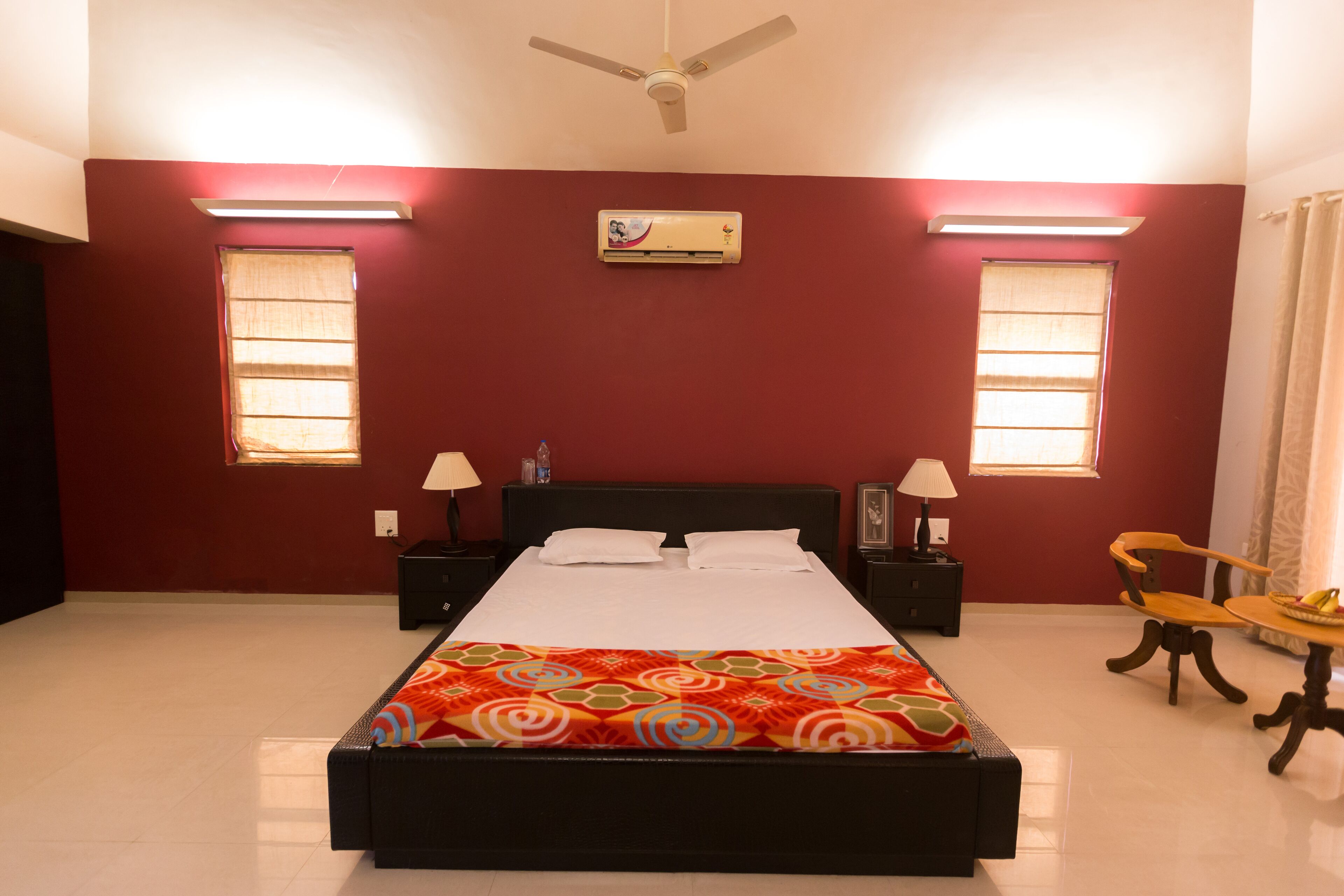 A bedroom with a bed, two bedside tables, a ceiling fan, and a window with curtains.