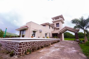 A modern house with a unique architectural design, featuring a stone base and a flat roof.
