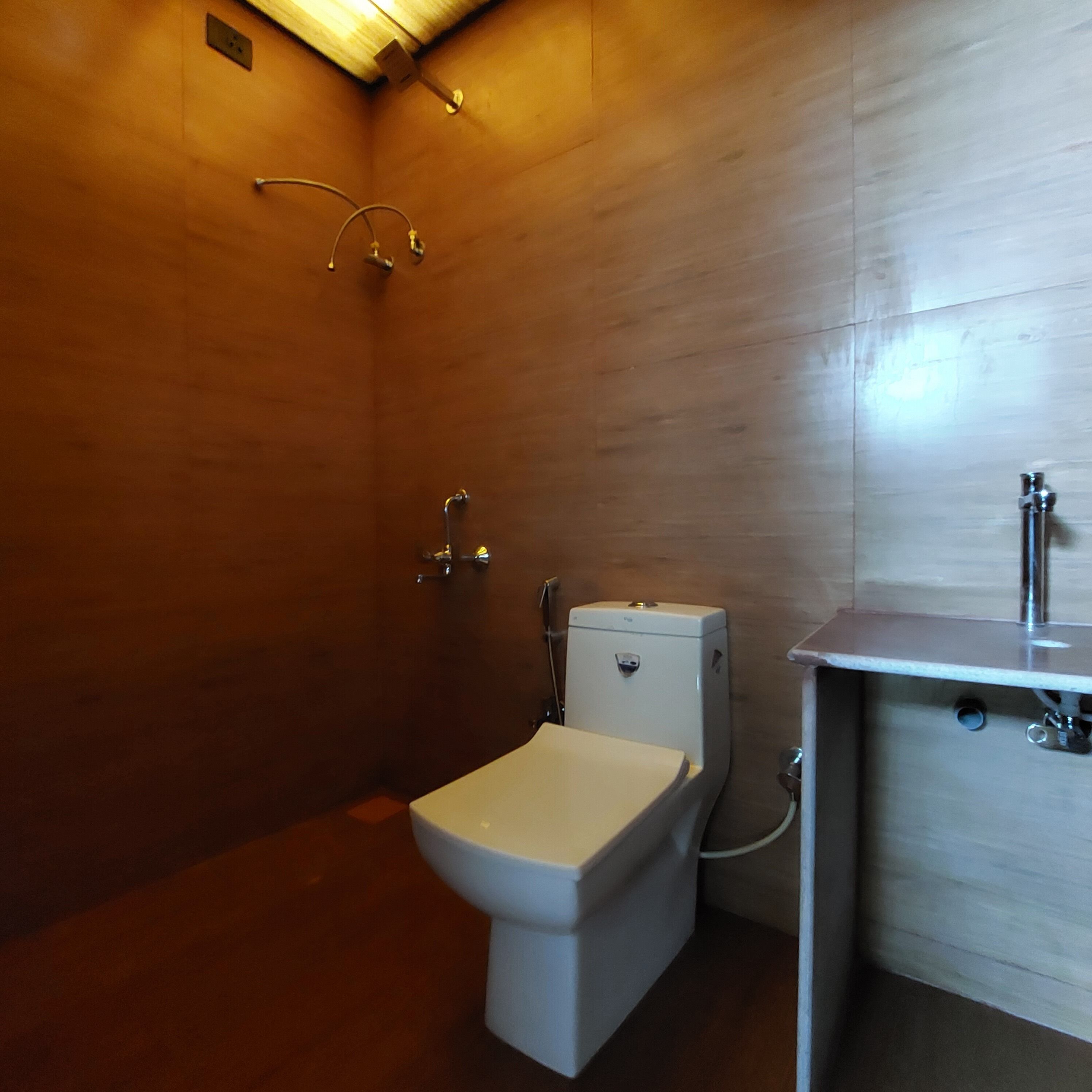 A bathroom with a toilet, a shower, and a sink.