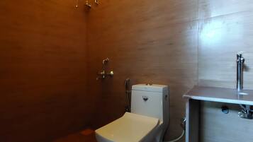 A bathroom with a toilet, a shower, and a sink.