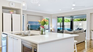 Una cocina moderna con una isla central, electrodomésticos de acero inoxidable y vistas al exterior.