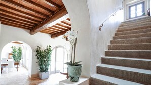 A staircase with a wooden ceiling and a potted plant on the landing.