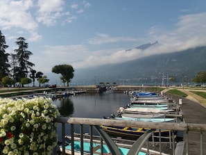 Een jachthaven met aangemeerde boten, een heldere lucht en bergen op de achtergrond.