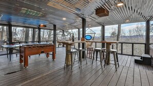An indoor space with a wooden floor, a foosball table, and a bar area with stools. - A Blue Ridge Mason Jar | Blue Ridge, GA (Blue Ridge)