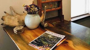 Une table en bois, un magazine, un vase rempli de fleurs et une décoration rustique.