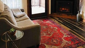 Un salon comprenant un canapé, un téléviseur, une cheminée et un ventilateur de plafond.