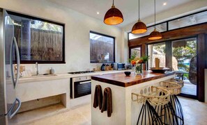 Enjoy cooking in this well-equipped kitchen with a central island, sink, and stainless steel appliances.