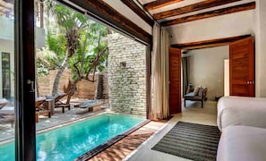 Relax by the pool with a view of lush greenery from the large window.