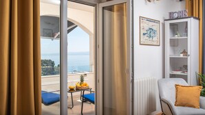 A room with a view of the sea, a balcony with a table and chairs, and a white cabinet with shelves. - ☆ Luxury apartment ☆ Heated pool ☆ Private parking (split)